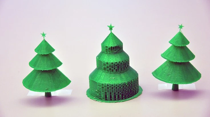 The Christmas tree in the center was 3D-printed in the traditional manner, and displays the extra material to support each branch. Beside it are the two halves of the same tree printed using the new algorithm, with no supportive material to remove.
