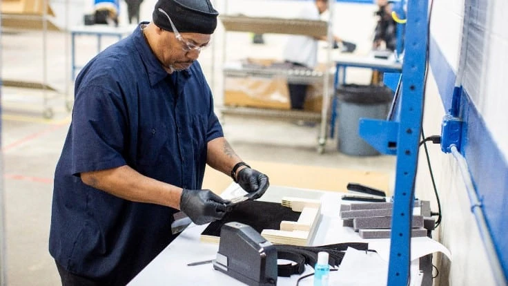 Workers at Ford Subsidiary Troy Design Manufacturing assembly face shields for medical workers.