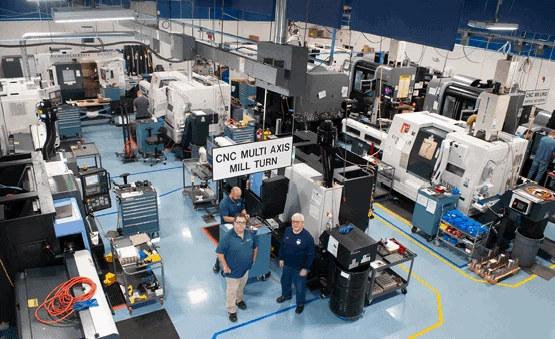 Ron Gronback Jr., PDQ CEO, and Scott Norman, manufacturing manager, in the foreground of the shop.