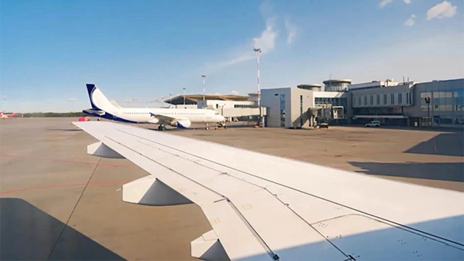 view looking out a jetliner window at another jet at a nearby airport gate