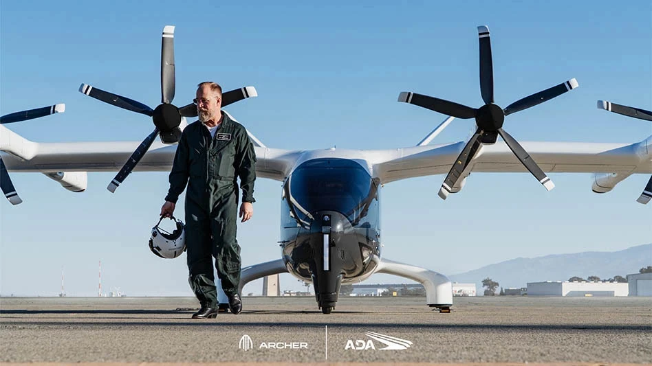 man walking in front of an air taxi parked on the ground