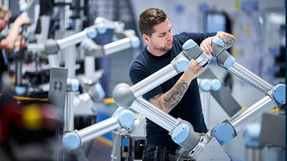 man adjusts cobot on an assembly line