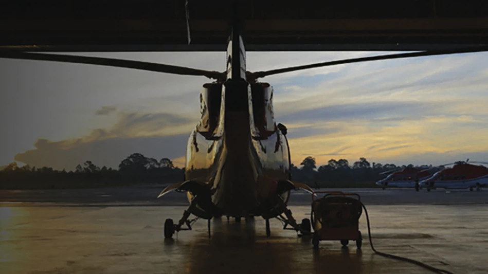 image of a helicopter on the ground with sunset sky behind
