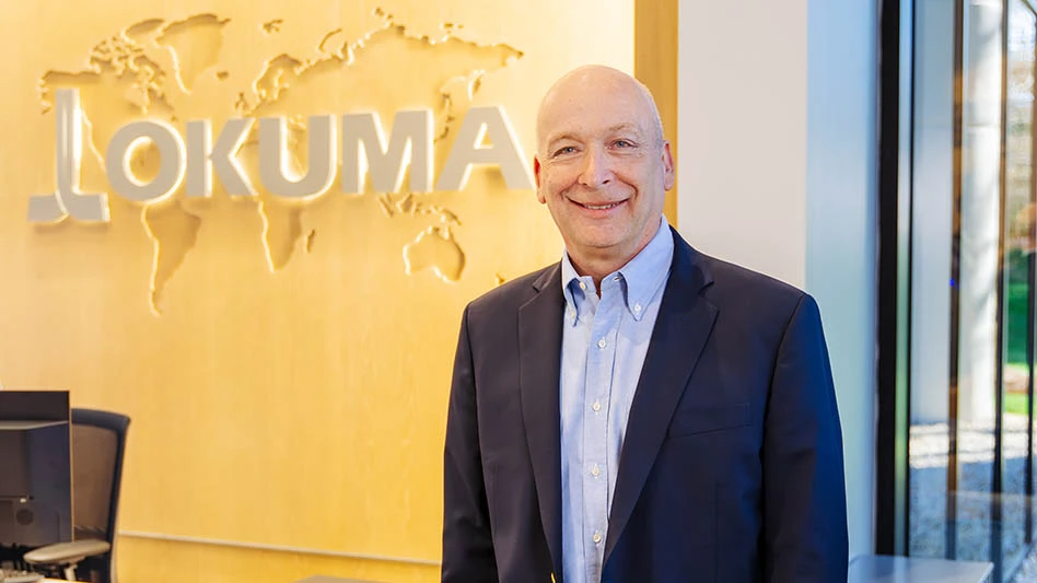 man standing in front of wall with corporate logo