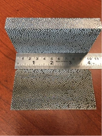 Composite metal foam with a ruler for scale.